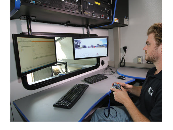 CUES control station with an operator at two monitors and a gamepad controller