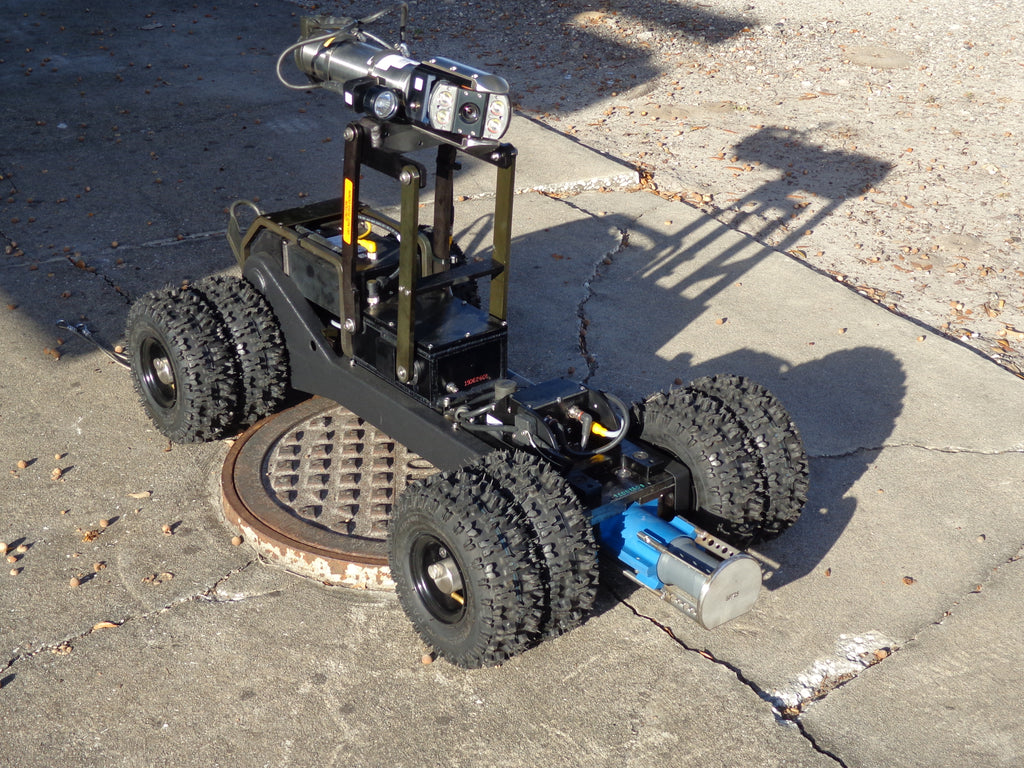 CUES CATVS black wheeled transporter with raised camera and sonar over a manhole cover