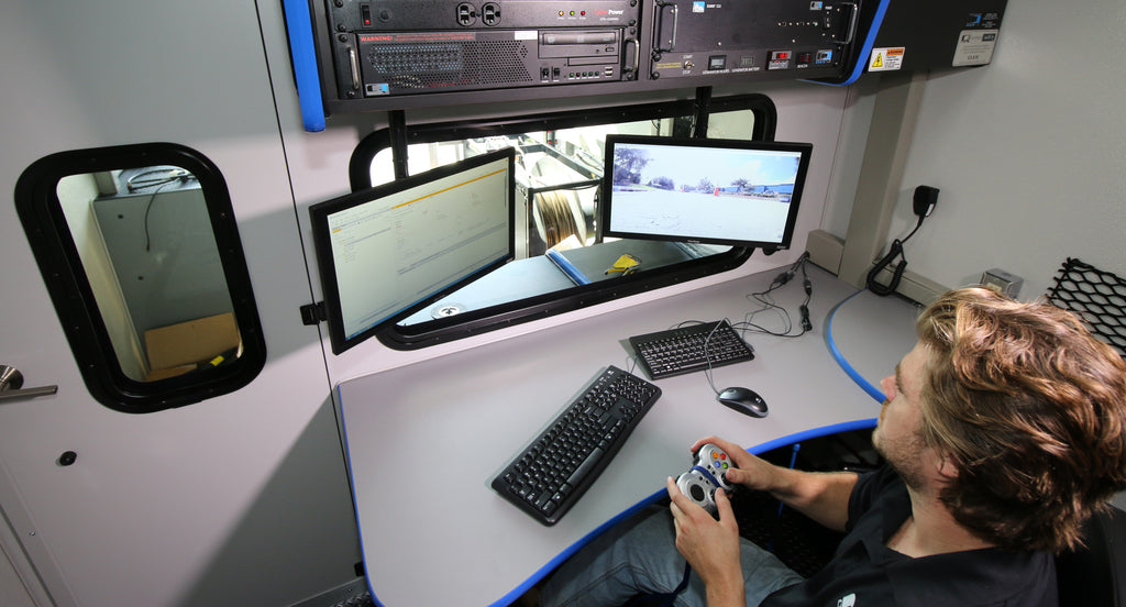 CUES GraniteNet software on control room monitors, operator at the desk with a handheld controller