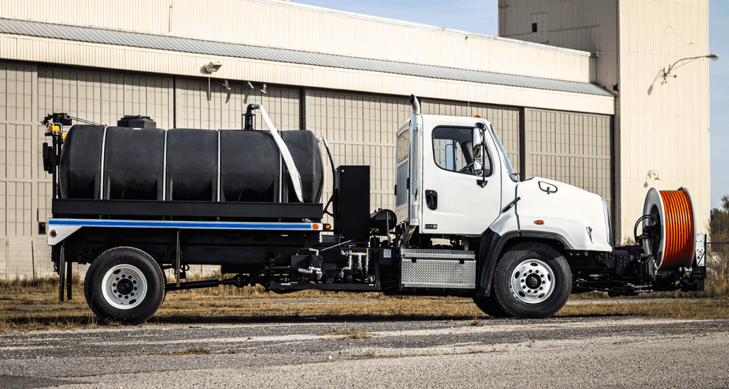 Vac-Con Hot Shot jetter truck with black water tank and front hose reel, passenger side view