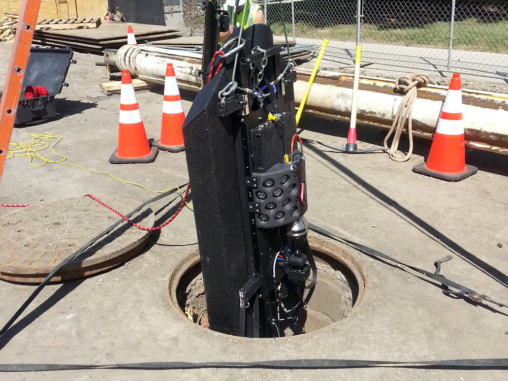 CUES SoLID FX lowered into a manhole at a job site with traffic cones